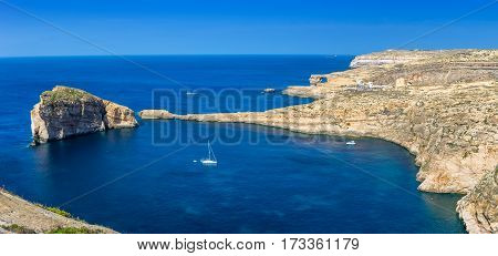 Gozo Malta - Panoramic skyline view of Dwejra bay with Fungus Rock Azure Window and sailboat on a nice hot summer day