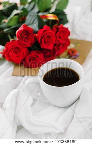 a bouquet of red roses coffee card with congratulations supply in bed