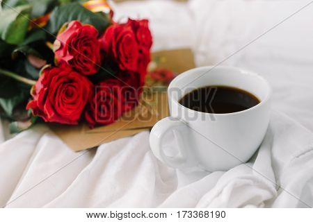 a bouquet of red roses coffee card with congratulations supply in bed