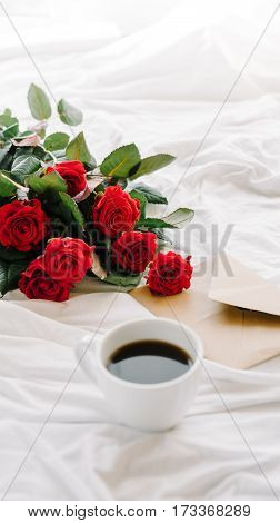 a bouquet of red roses coffee card with congratulations supply in bed