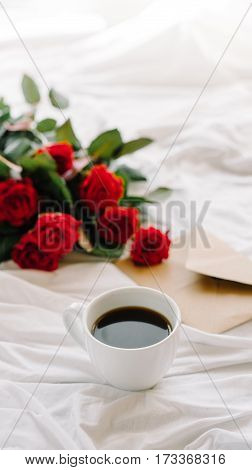 a bouquet of red roses coffee card with congratulations supply in bed