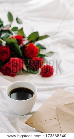 a bouquet of red roses coffee card with congratulations supply in bed