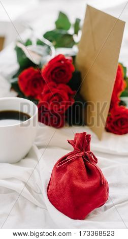 a bouquet of red roses coffee card with congratulations supply in bed