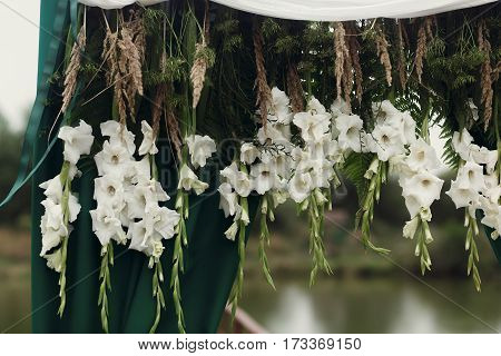 Beautiful White Gladioli And Wildflowers On Arch On Aisle At Lake At Wedding Outdoor Reception And C