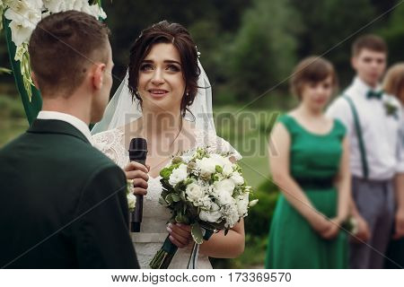Gorgeous Bride Crying While Taking Vows On Aisle At Lake At Wedding Outdoor Reception And Ceremony.