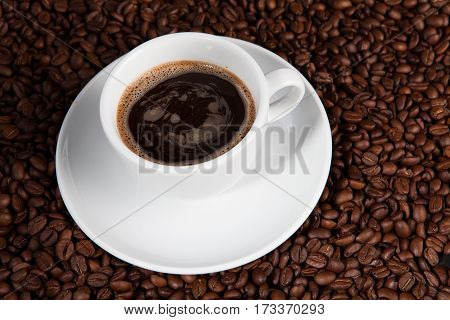 white cup of coffee beans at coffee beans