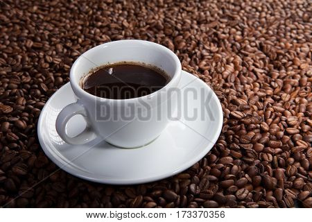 white cup of coffee beans at coffee beans