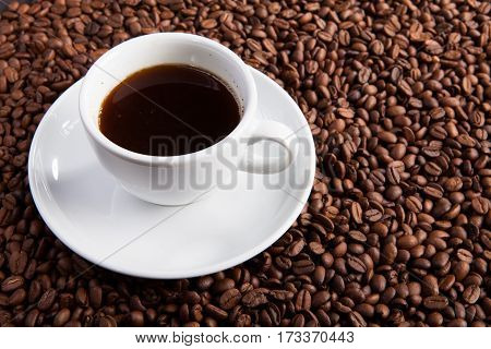 white cup of coffee beans at coffee beans