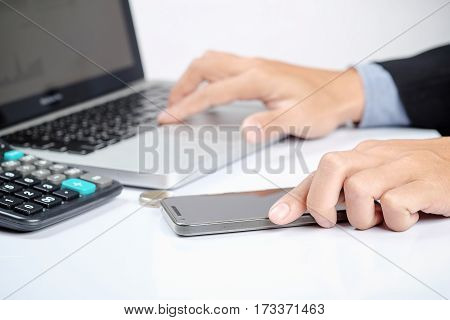 Asian Young Business Man Use Smartphone And Laptop Sitting At Wooden Table