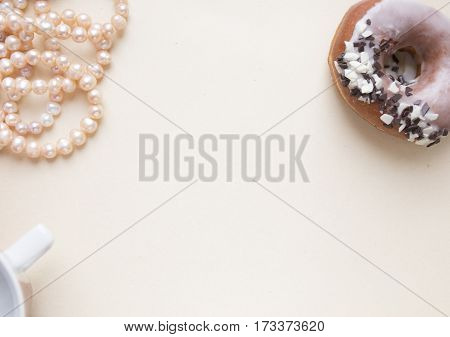 Blank craft background. Sheet of rough paper with rose pearls and donut. Mock up for letter writing, creative work concept.