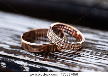 Golden wedding rings on wooden backrgound with small depth of field