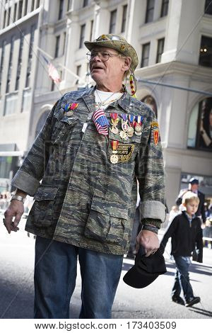 NEW YORK - 11 NOV 2016: A vet wearing a camouflage jacket with medals marches in the annual Americas Parade United War Veterans Council UWVC on 5th Avenue on Veterans Day in Manhattan.