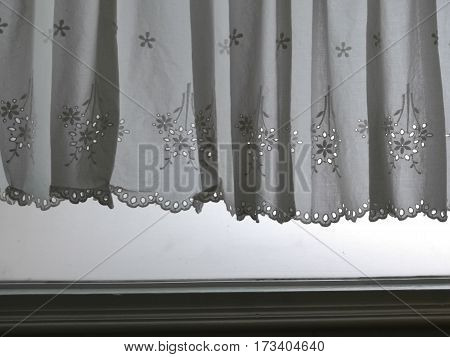 Silhouette white Lace satin curtain hanging on window above window jamp with sunlight semitransparent behind decoration interior room photo