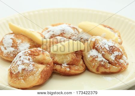 Poffertjes Dutch small fluffy pancakes served with powdered sugar and butter.