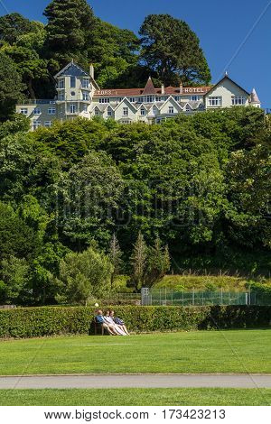Lynmouth Devon England 13 July 2016: Tors Hotel on the hill and people have a rest at the bottom on the bench