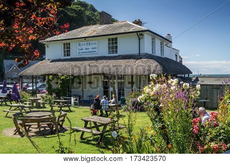 Lynmouth North Devon England 13 July 2016: Restaurant and Accommodations - Rock House. People sit at tables in the courtyard