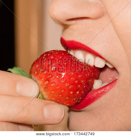 The girl taste a strawberry. Beauty photo.