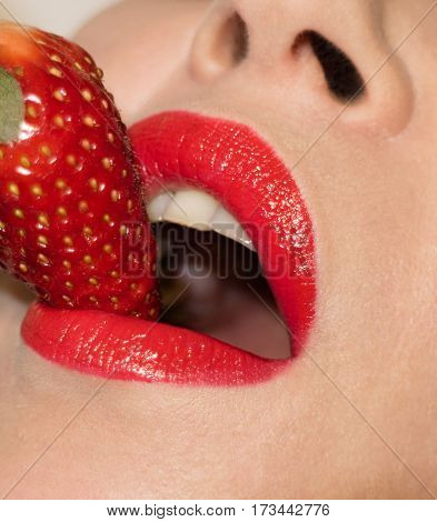 Beautiful passionate lips kissed strawberry. Young woman.