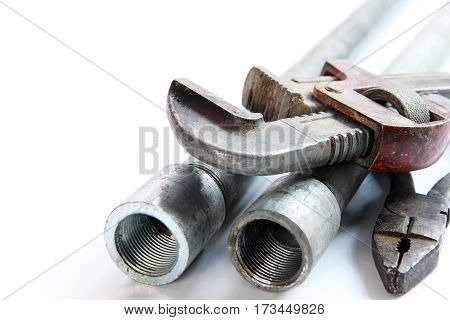 pipe alligator wrench pliers and steel pipes on white background