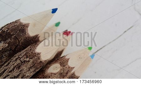 Bunch of colored pencils on a rustic white background