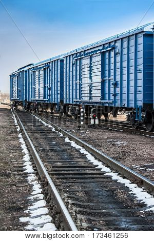 Blue freight cars stood on the rails with freight
