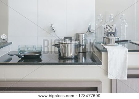 Stainless steel kitchenware on black top counter