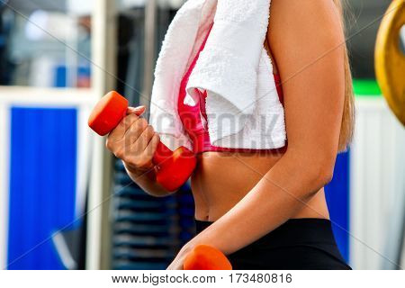 Woman holding dumbbell workout at gym. Weights for women. Middle section of bare belly. Set of heavy dumbbells on background. Body that you want concept.
