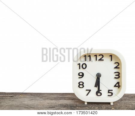 Closeup white clock for decorate show half past six or 6:30 a.m. on old brown wood desk isolated on white background with copy space