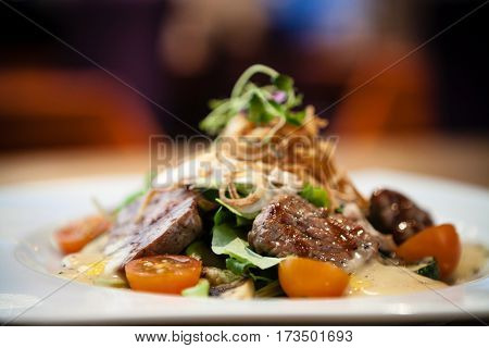 Brutus salad with beef tenderloin served on a plate