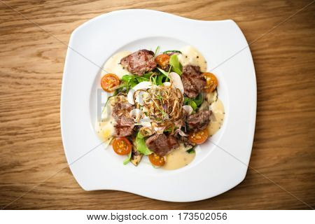Brutus salad with beef tenderloin served on a plate