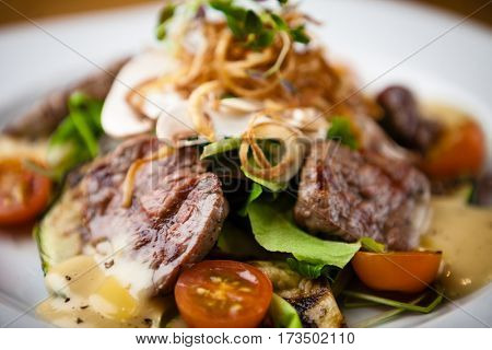 Brutus salad with beef tenderloin served on a plate