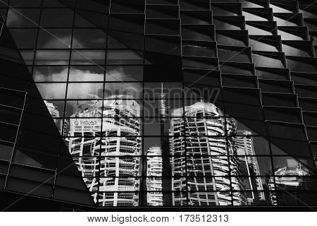 Sydney, Australia - 7 February, 2016; Distorted reflections of Sydney CBD buldings and Centrepoint Tower within the windows of a new building under construction in Sydney.  . Black and White.