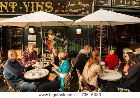 PARIS FRANCE - OCTOBER 11 2015: People communicating and drinking at terrace of typical cafe of Montmartre.