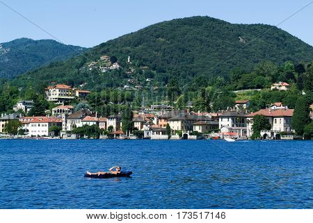 Man On An Inflatable Mattress Sunbathing In Front Of Orta