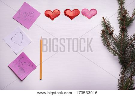 Wooden White Background With A Branch Of Pine And Three Hearts.