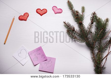 Wooden White Background With A Branch Of Pine And Three Hearts.