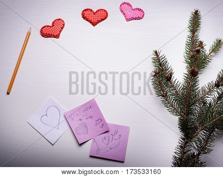 Wooden White Background With A Branch Of Pine And Three Hearts.
