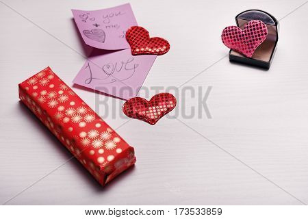 Wooden White Background With A Branch Of Pine And Three Hearts.
