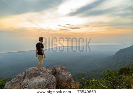 lonely young man stands on the mountain and looks into the distance, Kampot, Cambodia