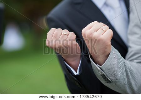 two male fist with wedding gold rings.