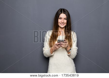 young woman with phone on grey background
