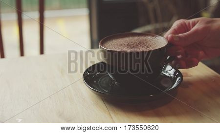 girl takes a mug of latte in cafe