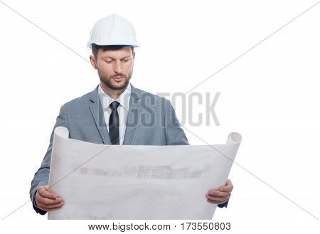 Putting plan into action. Handsome serious man wearing hardhat studying architectural blueprint he is holding isolated on white copyspace architecture engineering profession occupation specialist