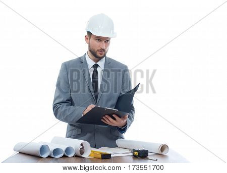 Engineering notes. Mature businessman engineer looking away thoughtfully while writing on his clipboard profession development building architectural project planning engineer profession concept