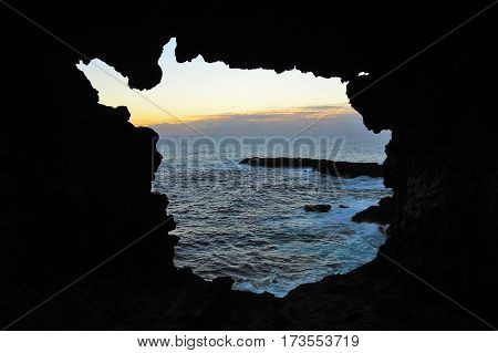 View onto the ocean during sunset through one of the windows at the Ana Kakenga Cave or two windows cave in Easter Island Rapa Nui Chile South America