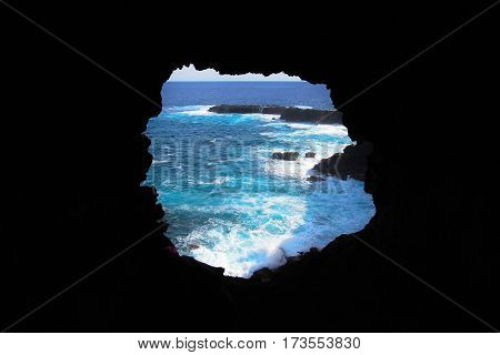 View onto the ocean during sunset through one of the windows at the Ana Kakenga Cave or two windows cave in Easter Island Rapa Nui Chile South America