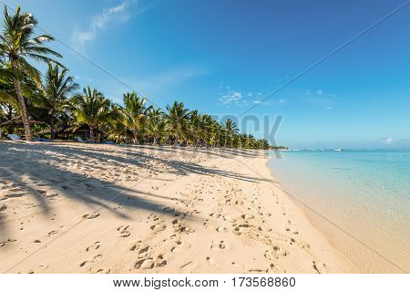 Le Morne Mauritius - December 11 2015: People are relaxing on the tropical beach with coconut palms one of the finest beaches in Mauritius. Shadow on sand.