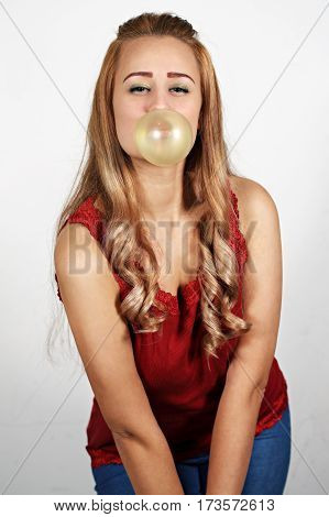 Young woman making a big bubble with a chewing gum
