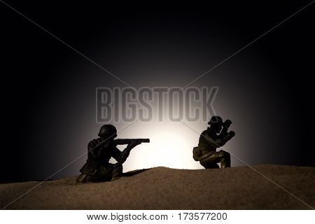 Silhouette of soldiers with rifle on a dark background