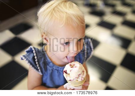 Little Girl Eating Ice Cream Cone In Old Fashioned Candy Shop